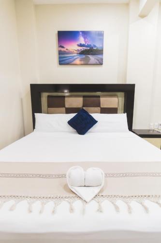a white bed with two white hearts on it at Casa Arizona in Brisas de Zicatela