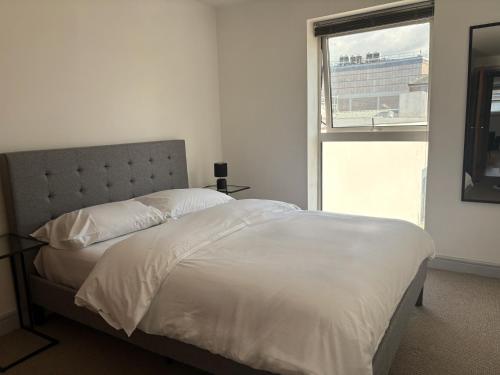 a bedroom with a white bed with a window at York City Centre 2 Bed Flat with Views - Top Location in York