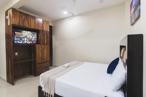 a bedroom with a bed and a television in it at Casa Arizona in Brisas de Zicatela