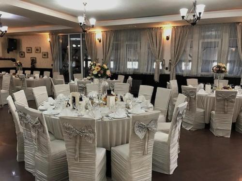 a banquet hall with white tables and white chairs at Pensiunea Bianca in Botoşani