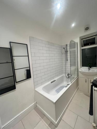 a white bathroom with a tub and a sink at 3bd in leicester near M1 - city - contractors in Leicester