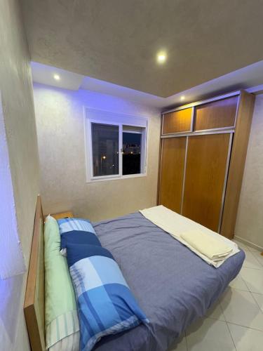 una cama grande en una habitación con ventana en Relax Appart, en Martil