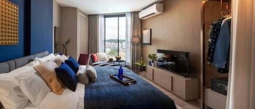 a bedroom with a large bed and a television at The Edge Central Pattaya Tops Luxury New Project in Ban Nong Chaeng