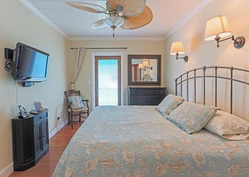 a bedroom with a bed and a flat screen tv at Beach Condo With Heated Pool, Coral Resort A1 in Clearwater Beach