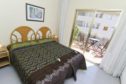 a bedroom with a bed and a door to a patio at Magica Planetcostadorada in Cambrils
