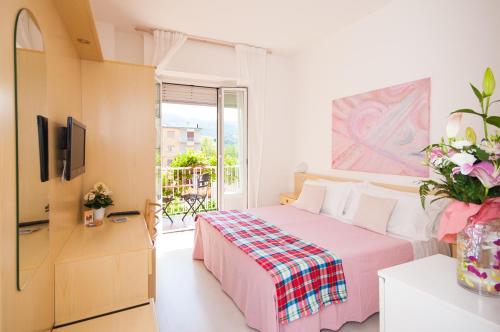 - une chambre avec un lit rose et une fenêtre dans l'établissement Hotel Giongo, à Spotorno