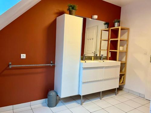 a bathroom with a sink and a mirror at La Maison Bleue à 40m de la plage in La Turballe