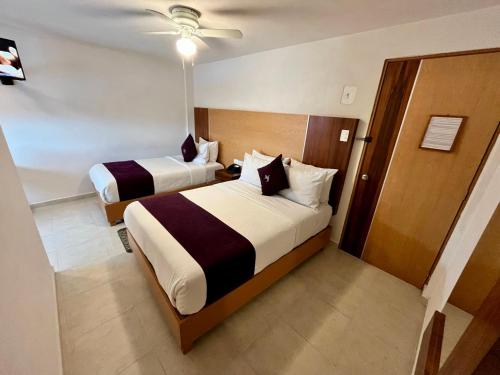 a hotel room with two beds and a door at Hotel Posada Maria Sofia in Cholula