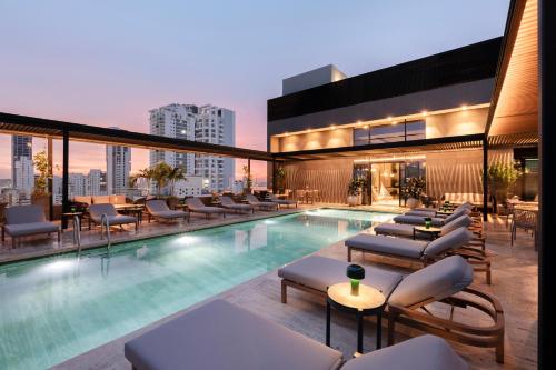 Una piscina con tumbonas y un edificio. en OZ Hotel Collection, en Cartagena de Indias