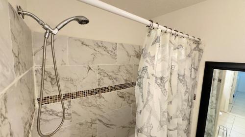 a shower in a bathroom with a shower curtain at The Poolside Escape Near Beaches in Port Saint Lucie