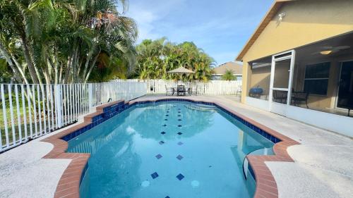 a swimming pool in front of a house at The Poolside Escape Near Beaches in Port Saint Lucie