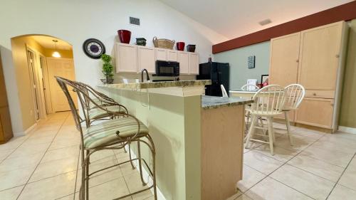 a kitchen with a counter and chairs in a room at The Poolside Escape Near Beaches in Port Saint Lucie