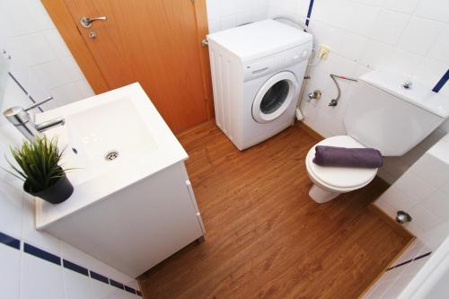 a bathroom with a toilet and a sink and a washing machine at Mexico Planetcostadorada in Vilafortuny
