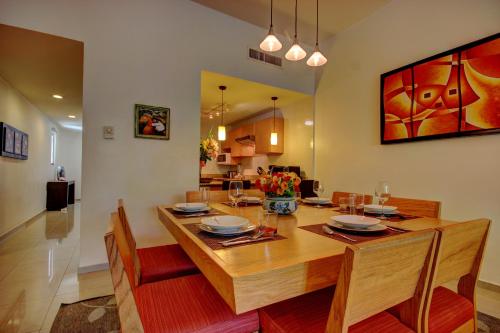 a dining room with a wooden table and chairs at Palmar del Sol by Riviera Maya Suites in Playa del Carmen