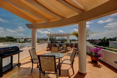 a patio with chairs and tables on a roof at Palmar del Sol by Riviera Maya Suites in Playa del Carmen