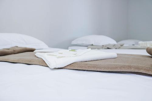 a group of white towels on a bed at Pousada Vilela in São Mateus