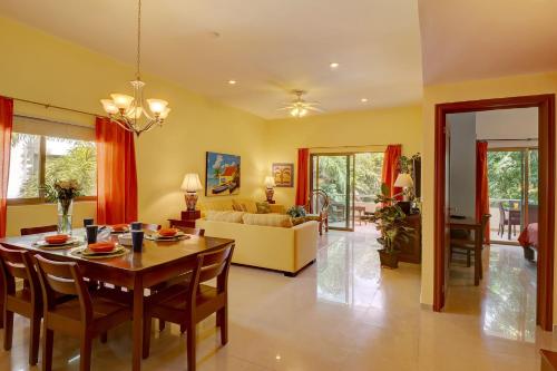 a dining room and living room with a table and chairs at Palmar del Sol by Riviera Maya Suites in Playa del Carmen
