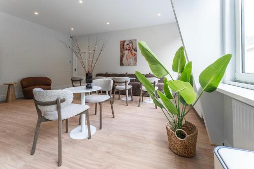 a dining room with tables and chairs and a plant at New Bed-room, Nature Location,university Tilburg in Tilburg
