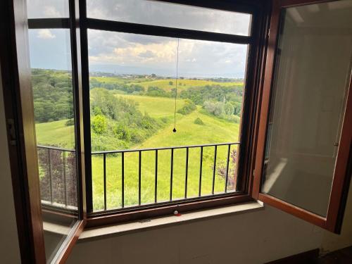 a window with a view of a green field at La Casa Di Giulia in Rome