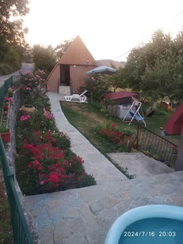a garden with pink flowers and a fence at Seoski dom in Šavnik