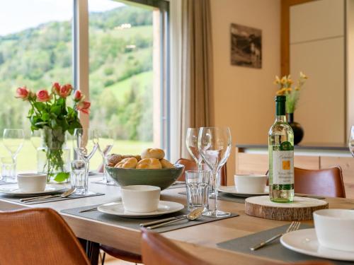 a dining table with a bottle of wine and a window at Mountain Vista in Sankt Lorenzen ob Murau