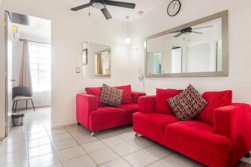 a red couch in a living room with a mirror at Hermosa CASA en privada, ingreso las 24 h in Cancún