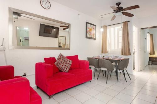 a living room with a red couch and a table at Hermosa CASA en privada, ingreso las 24 h in Cancún
