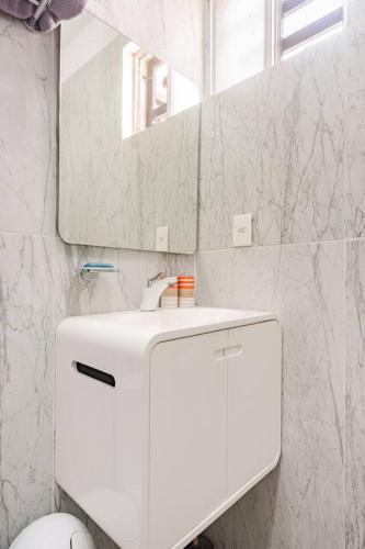 a white bathroom with a sink and a mirror at Hermosa CASA en privada, ingreso las 24 h in Cancún