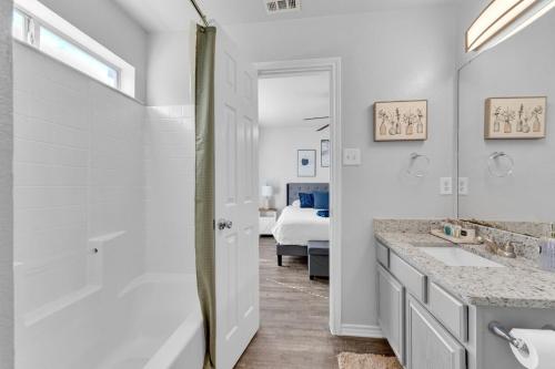 a white bathroom with a shower and a sink at The Sunset Suite 3Bd 2Bath Att Garage Pvt Yard in Glenn Heights
