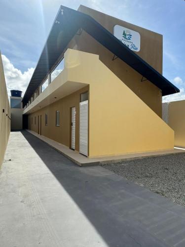 a yellow building with a black roof at Pousada Brisa Rio in Aracaju