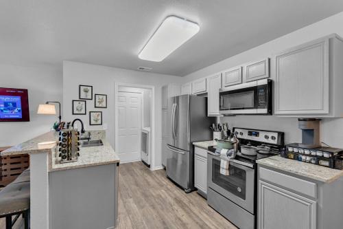 a kitchen with stainless steel appliances and white cabinets at The Sunset Suite 3Bd 2Bath Att Garage Pvt Yard in Glenn Heights