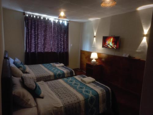 a hotel room with two beds and a window at Golden Bird in Mindo
