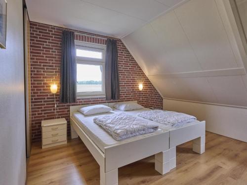 a bed in a room with a brick wall at t Achterhoes in Diepenheim