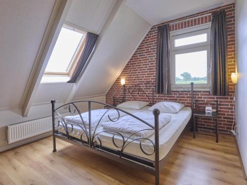a bedroom with a bed and a brick wall at t Achterhoes in Diepenheim