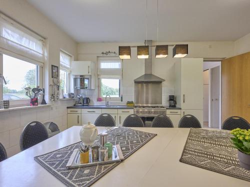 a large kitchen with a table and chairs in it at t Achterhoes in Diepenheim