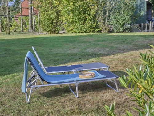 a blue bench sitting in the grass in a park at t Achterhoes in Diepenheim