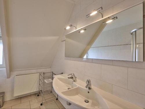 a white bathroom with a sink and a mirror at t Achterhoes in Diepenheim