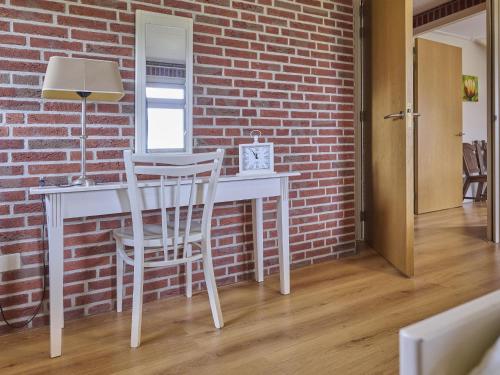 a white desk with a chair next to a brick wall at t Achterhoes in Diepenheim