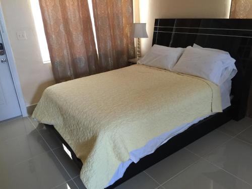 a bedroom with a large bed with a black headboard at Pelican By The Sea in Pompano Beach