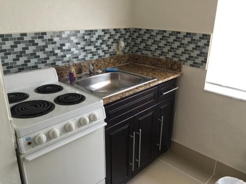 a kitchen with a stove and a sink at Pelican By The Sea in Pompano Beach