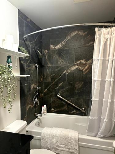 ein Badezimmer mit einer Badewanne mit einer schwarzen Wand in der Unterkunft Falcon Escape in Calgary
