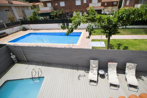 a swimming pool with two chairs and a table at Dream Planetcostadorada in Salou