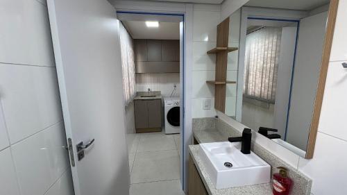 a bathroom with a sink and a mirror at Residencial Franciscano - Perto de TUDO com vaga! LZN Hospedagens in Santa Maria