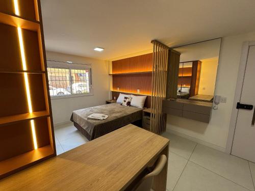 a small room with a bed and a table at Residencial Franciscano - Perto de TUDO com vaga! LZN Hospedagens in Santa Maria