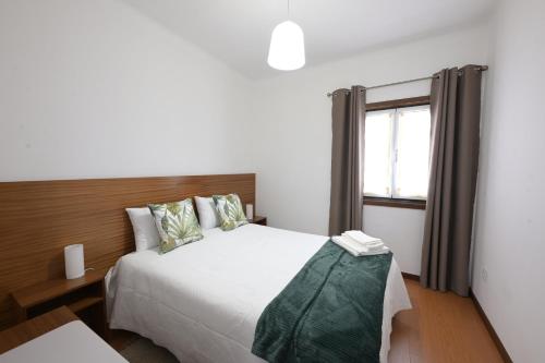 a bedroom with a bed and a window at Quinta da Bouça - Casa das Cangas in Vale de Cambra