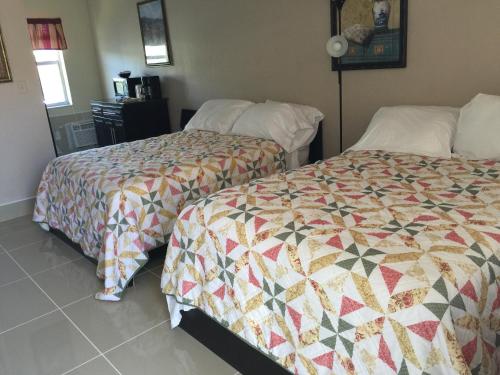 a hotel room with two beds and a quilt at Pelican By The Sea in Pompano Beach