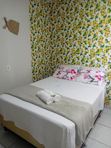 a bedroom with a bed with a floral wallpaper at Pousada da Sami in Barra de São Miguel