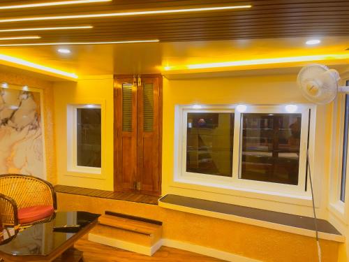 a yellow room with a window and a chair at Alice Lake Promise in Alleppey