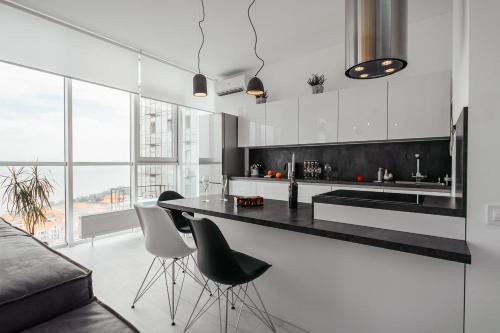 a kitchen with a black counter and white cabinets at Sea and Sky Apartment in Odesa