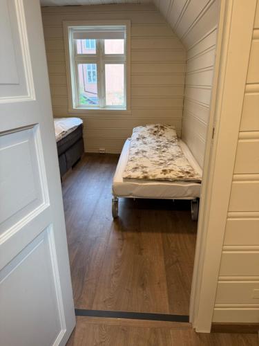 a small room with a bed and a window at Nyrenovert Bergenshus med 2 leiligheter - rolig smau i hjertet av Bergen in Bergen